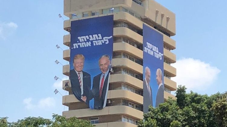 В Тель-Авиве на офисе правящей партии появились плакаты с Нетаньяху, жмущим руку Путину и Трампу
