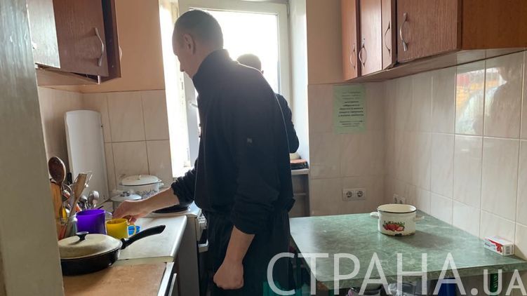 Двое бездомных, которые ночуют в Доме социальной опеки в Киеве, готовят себе обед. Фото: Страна