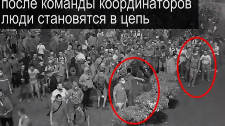 Двое координаторов выстраивают людей в цепь. Скриншот видео Следственного комитета Беларуси