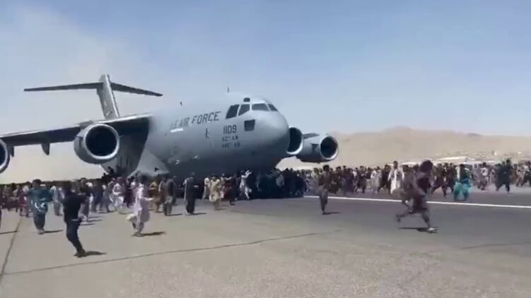 Афганцы бегут за военно-транспортным самолетом США. Кадр из видео