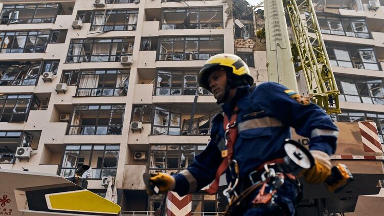 Спасатель ликвидирует последствия попадания по жилому дому в Киеве. Фото ГСЧС